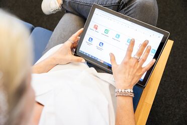 Eine Person nutzt ein Tablet, um die Dokumentation des Open Source Dokumentenmanagement-Systems zu durchsuchen.