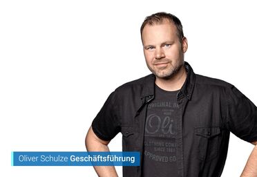 Oliver Schulze, Geschäftsführer der agorum Software GmbH, trägt ein schwarzes Hemd und steht mit verschränkten Armen.
