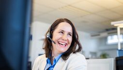 Ein Mitarbeiter im Büro trägt ein Headset und arbeitet am Computer, um Support für agorum Business Partner zu bieten.