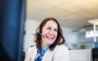 Ein Mitarbeiter im Büro trägt ein Headset und arbeitet am Computer, um Support für agorum Business Partner zu bieten.