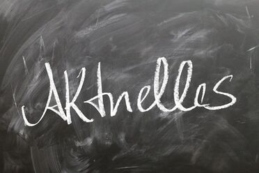 Eine Tafel mit der Aufschrift 'Aktuelles' zeigt den Jahresrückblick 2021 für Dokumentenmanagement.