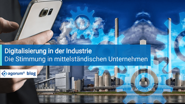 Eine Hand hält ein Smartphone vor einer Industrieanlage, die mit digitalen Zahnrädern überlagert ist, symbolisiert die Digitalisierung in der Industrie und die Stimmung in mittelständischen Unternehmen.
