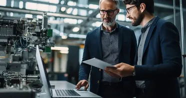 Zwei Männer mit Tablet und Laptop digitalisieren Geschäftsprozesse. Das Dokumentenmanagement hilft bei der Digitalisierung.