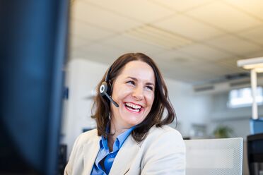 Ein Mitarbeiter im Büro trägt ein Headset und arbeitet am Computer, um Support für agorum Business Partner zu bieten.