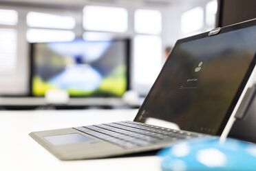 Ein Laptop zeigt den Login-Bildschirm des Open Source Dokumentenmanagementsystems agorum core in einem modernen Büro.