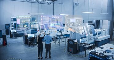 Zwei Personen in einer modernen Industriehalle betrachten verschiedene digitale Schnittstellen und Datenvisualisierungen, die auf Dokumentenmanagement und Digitalisierung hinweisen.