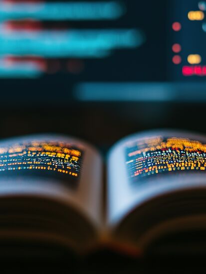 Ein geöffnetes Buch mit Code auf den Seiten zeigt die Changelog-Übersicht des Dokumentenmanagement-Systems.