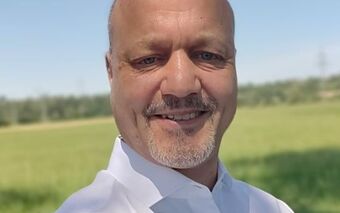 OrgSoft GmbH Mitarbeiter steht auf einer Wiese unter blauem Himmel, Partner 2023