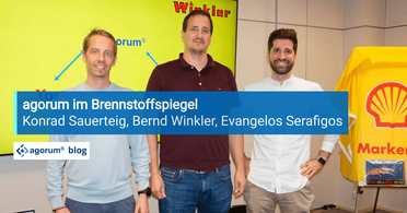 Drei Personen stehen vor einem Schild mit der Aufschrift Winkler und einem Shell-Markenstand, im Zusammenhang mit dem Einsatz von Dokumentenmanagement im Mineralöl- und Brennstoffhandel.