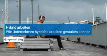 Ein Mitarbeiter sitzt mit Kopfhörern auf einer Bank und arbeitet von einem externen Standort aus, was die Flexibilität des hybriden Arbeitens zeigt.