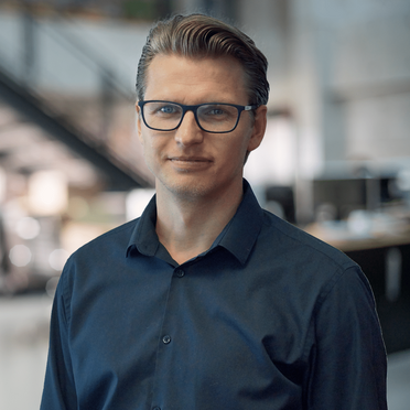 Michael Jacobi, Account Manager bei GODYO Business Solutions AG, steht in einem modernen Büro.