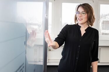 Eine Mitarbeiterin präsentiert das digitale Toolkit an einem interaktiven Whiteboard im Büro.