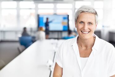 Ein Mitarbeiter präsentiert vor einer Gruppe im Konferenzraum während eines Strategie-Workshops für agorum-Partner.