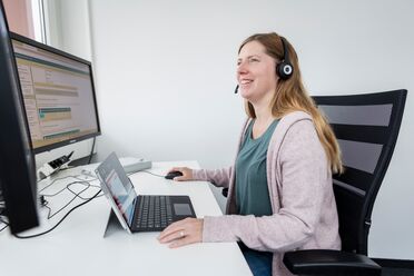 Eine Mitarbeiterin nutzt agorum core auf einem Monitor und einem Tablet für eine individuelle Schulung.