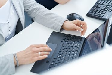 Eine Mitarbeiterin nutzt ein Laptop zur Archivierung von E-Mails im Dokumentenmanagementsystem.