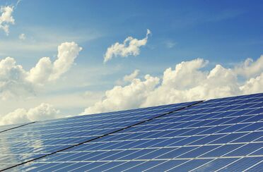 Photovoltaik-Anlagen von Küstenhaus Energie Technik GmbH unter blauem Himmel mit weißen Wolken, symbolisieren die Nutzung von Open Source DMS für die Digitalisierung von Geschäftsprozessen.