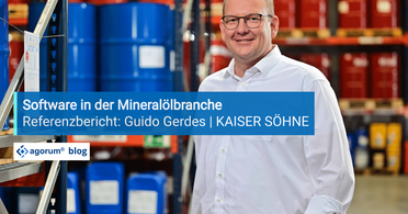 Ein Mitarbeiter von Kaiser Söhne steht in einem Lager mit blauen und roten Fässern, das digitale Dokumentenmanagement-System wird vorgestellt.