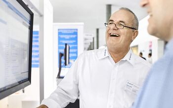 Ein Mitarbeiter von ACP Digital Business Solutions zeigt auf einem Bildschirm das Dokumentenmanagement-System.