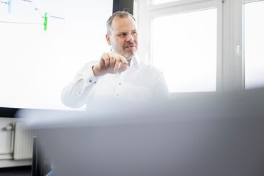 Ein IT-Administrator zeigt auf ein Diagramm während einer Schulung zur effektiven Administration von agorum core.