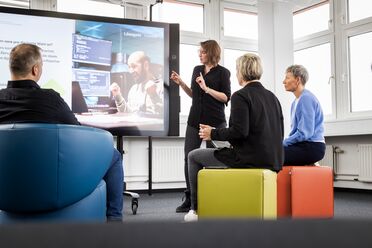 Eine Trainerin präsentiert auf einem großen Bildschirm Inhalte zur Dokumentenmanagement-Software während einer Schulung in der agorum Academy.