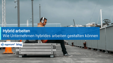 Ein Mitarbeiter sitzt mit Kopfhörern auf einer Bank und arbeitet von einem externen Standort aus, was die Flexibilität des hybriden Arbeitens zeigt.