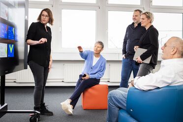 Eine Trainerin erklärt vor einem interaktiven Whiteboard die Funktionen des Dokumentenmanagement-Systems während einer TeamReady Onboarding Schulung.