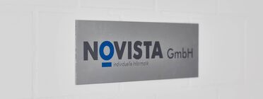 Ein Firmenschild an der Wand zeigt den Namen NOVISTA GmbH und den Slogan 'individuelle Informatik'.