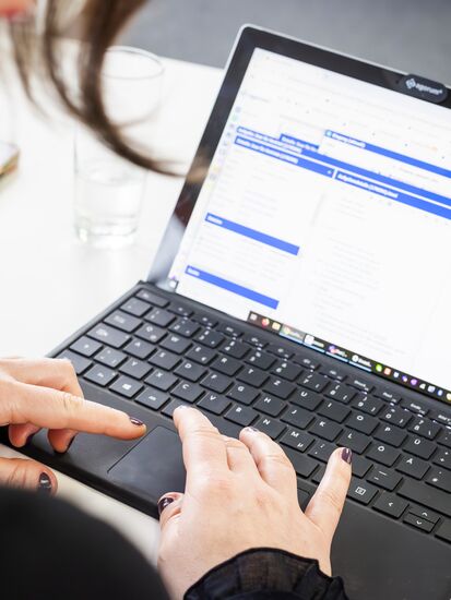 Ein Laptop zeigt die Benutzeroberfläche des Dokumentenmanagement-Systems agorum core mit verschiedenen Use Cases.