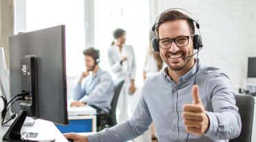 Ein Mitarbeiter im Büro zeigt mit dem Daumen hoch auf die Automatisierung des Buchhaltungsprozesses mit DATEV und Dokumentenmanagement-System.