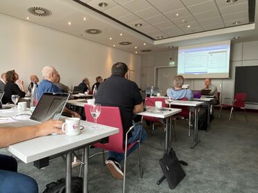 Teilnehmer der agorum Partnertage 2024 sitzen an Tischen und diskutieren über Innovationen im Dokumentenmanagement.