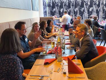 Teilnehmer der agorum Partnertage 2025 sitzen an einem Tisch im Mercure Hotel Stuttgart Airport Messe und tauschen sich aus.