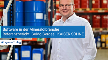 Ein Mitarbeiter von Kaiser Söhne steht in einem Lager mit blauen und roten Fässern, das digitale Dokumentenmanagement-System wird vorgestellt.