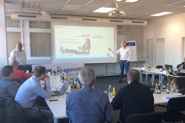 Oliver Schulze präsentiert auf dem agorum Partnertag 2014 vor einer Gruppe von Teilnehmern im Konferenzraum.