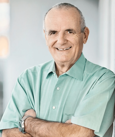 Rolf Lang, Geschäftsführer von agorum, trägt ein hellblaues Hemd und eine Uhr, steht mit verschränkten Armen im Büro.