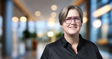 Jeannette Krause, HR-Verantwortliche bei agorum Software GmbH, steht in einem modernen Bürogebäude.