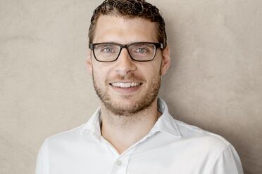 Matthias Zbären trägt ein weißes Hemd und steht vor einer neutralen Wand. Er ist Mitarbeiter bei Zbären Treuhand.