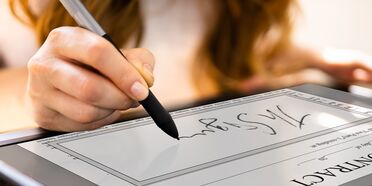 Eine Person signiert ein Dokument elektronisch mit einem Stift auf einem Tablet, das zeigt, wie einfach elektronische Signaturen mit inSign sind.