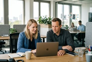 Zwei Kolleginnen verfolgen gemeinsam am Laptop das agorum® Campus Webinar zu KI-Agenten und KI-Tools