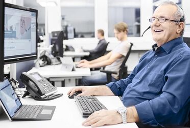 Ein agorum Partner arbeitet am Schreibtisch mit einem Computer, auf dem eine Dokumentenmanagement-Software angezeigt wird.